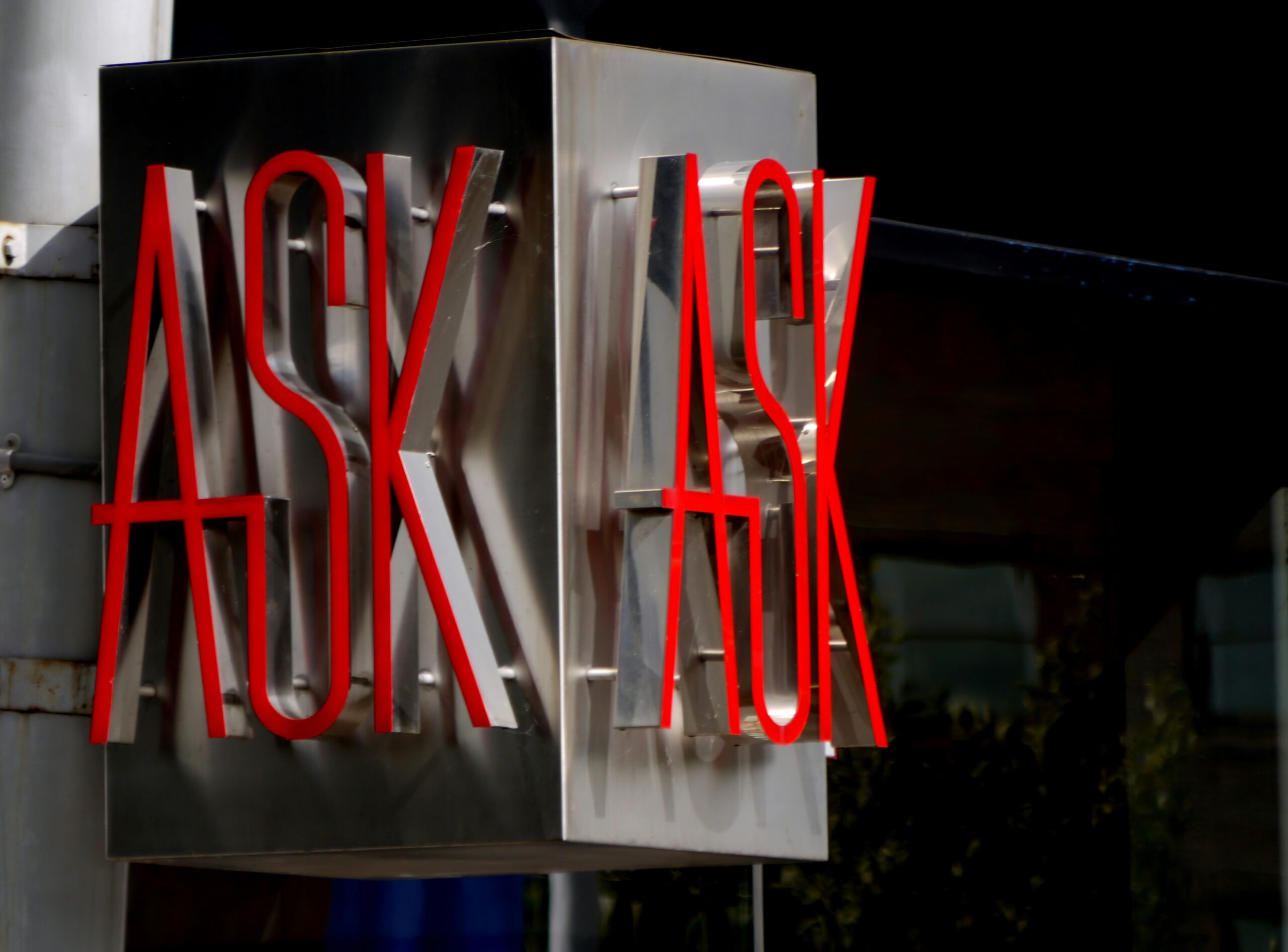 A neon sign reading “ask” on both sides